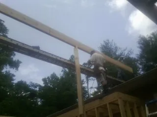Carpenter setting a ridge beam over a new addition frame — Ice Dam Removal by Roofing Brothers in Cedar Run